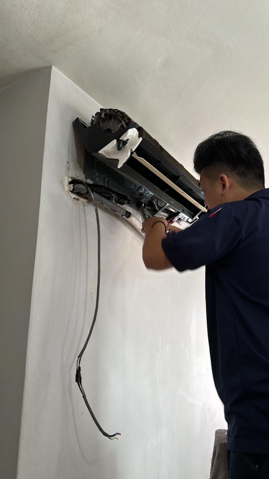Cool Aircon technician servicing an air conditioning unit in Singapore